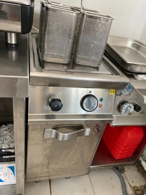 une cuisine avec de nombreux éléments en inox sur le plan de travail