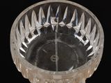 a clear glass bowl on a wooden table with a black background