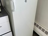a white refrigerator with a red bag on top of it