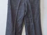 gray pants hanging on a white wall next to a chair