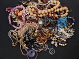 a pile of assorted beads and jewelry on a black surface