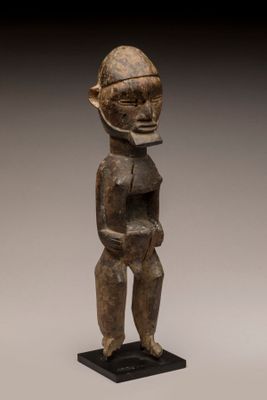 une statue en bois représentant un homme portant un casque sur la tête