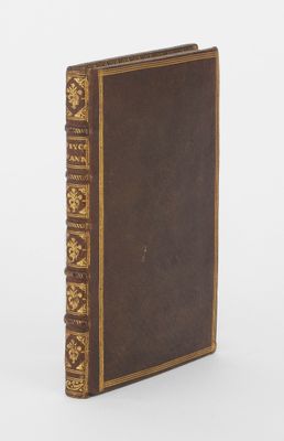 un vieux livre à la couverture brune et à la bordure dorée