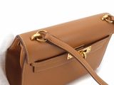 the small brown leather bag is on a white surface