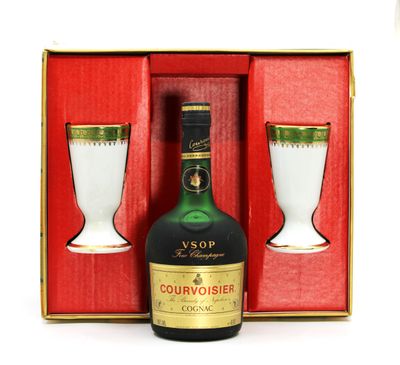 a bottle of courvoisier next to a glass in a box