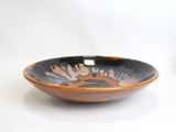 a black and orange bowl sitting on a white table