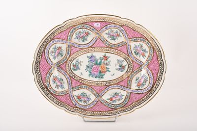 une assiette rose et dorée ornée d'un motif floral