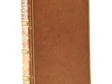 an old book sitting on top of a white table next to a white wall