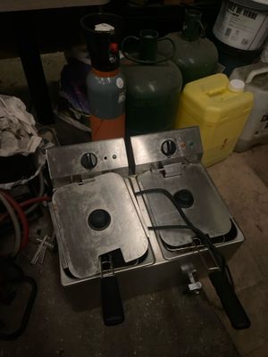 two deep fryers that are sitting on a table