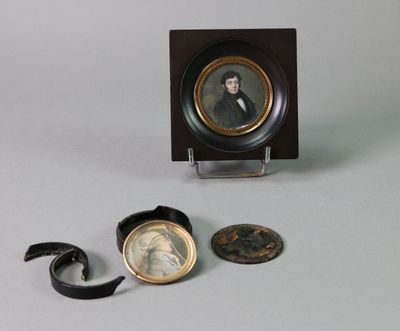 a miniature picture of a man in a suit and tie on a table