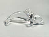 a glass figurine of a cat laying on a table
