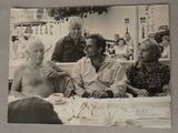 une photo en noir et blanc d'un groupe de personnes assises à une table