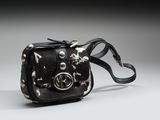 sac à bandoulière noir et argent parsemé d'étoiles sur fond gris