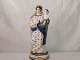 une figurine représentant une femme tenant un enfant dans ses bras
