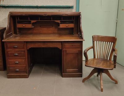 a wooden desk with a chair next to it in a room