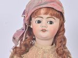 a doll that is wearing a pink dress and a pink hat