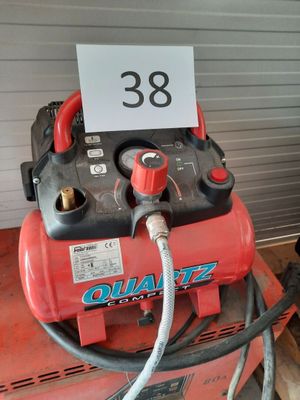 a red air compressor sitting on top of a pallet