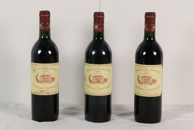 trois bouteilles de vin rouge sont alignées sur une table