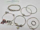 several different bracelets and rings are on a white surface
