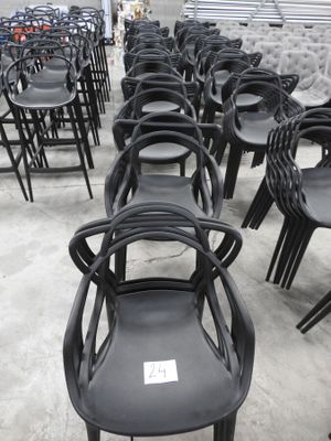 des rangées de chaises en plastique noir dans un entrepôt qui en regorge