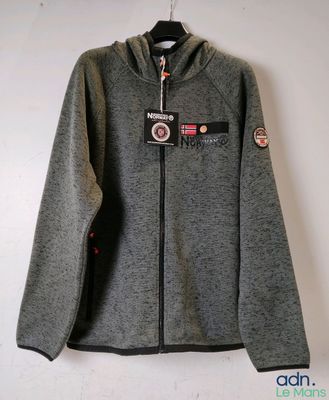 un gros plan sur une veste grise accrochée à un mur