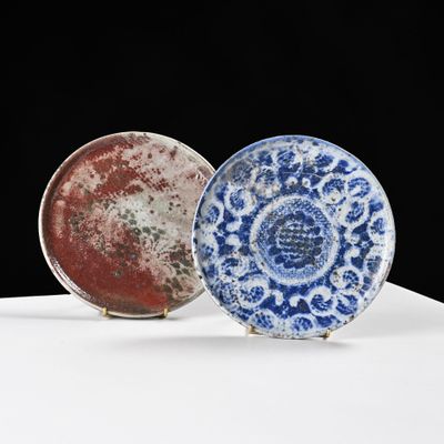 une paire d'assiettes bleues et blanches posées sur une surface blanche, sur fond noir
