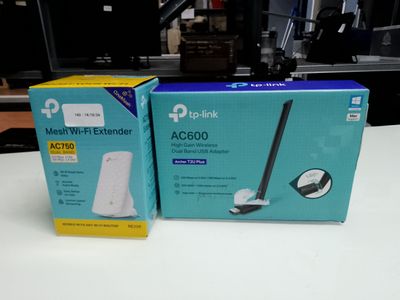 two boxes of wireless devices sitting on top of a white table
