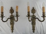 pair of antique brass wall sconces with candles on each of them