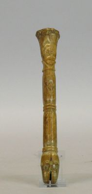 Fragment d’outil en os à patine d’usage orné à son sommet d’…