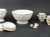 a group of white and gold items on a black surface