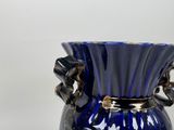 a blue vase with a gold handle on a table