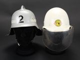 pair of white hard hats sitting on top of each other on a black surface