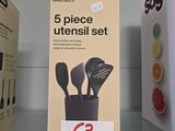trois boîtes d'ustensiles posées sur une étagère dans un magasin