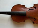 Un vieux violon est accroché au mur.