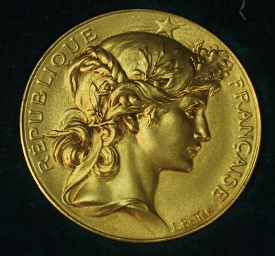 a close up of a gold coin with a woman ' s face