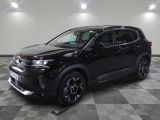 Un SUV noir est garé sur un sol à damier dans un garage.