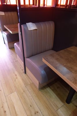 a booth with a table and two chairs in front of it