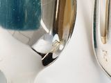 two spoons that are sitting next to each other on a table