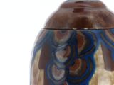 a blue and brown vase sitting on a white surface