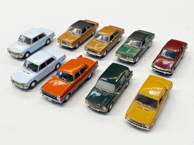 plusieurs petites voitures sont alignées sur une surface blanche