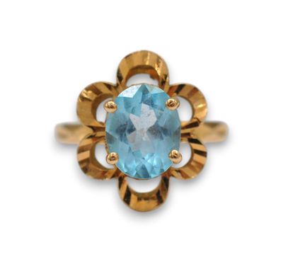 a gold ring with a blue topaz stone in the center