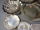 a lot of silver plates and trays sitting on a table