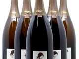 six bouteilles de vin sont alignées sur une table