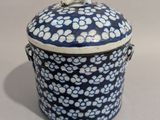 un récipient bleu et blanc orné d'un motif floral