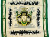 un gros plan sur une écharpe verte et blanche ornée d'un blason