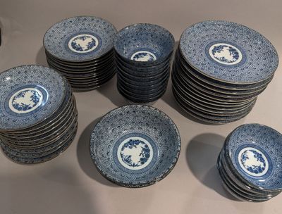 beaucoup d'assiettes bleues et blanches posées sur une table