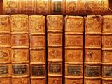 many old books that are on a shelf together