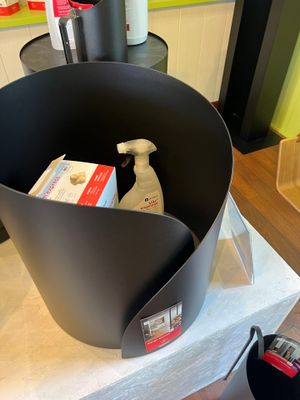 a black bucket with a bottle of cleaner and a bottle of soap in it