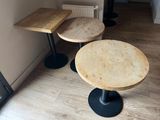 two tables and two stools in the corner of a room