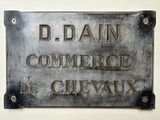 une pancarte accrochée au mur sur laquelle on peut lire « D'Bain Commerce de Cirvaux »